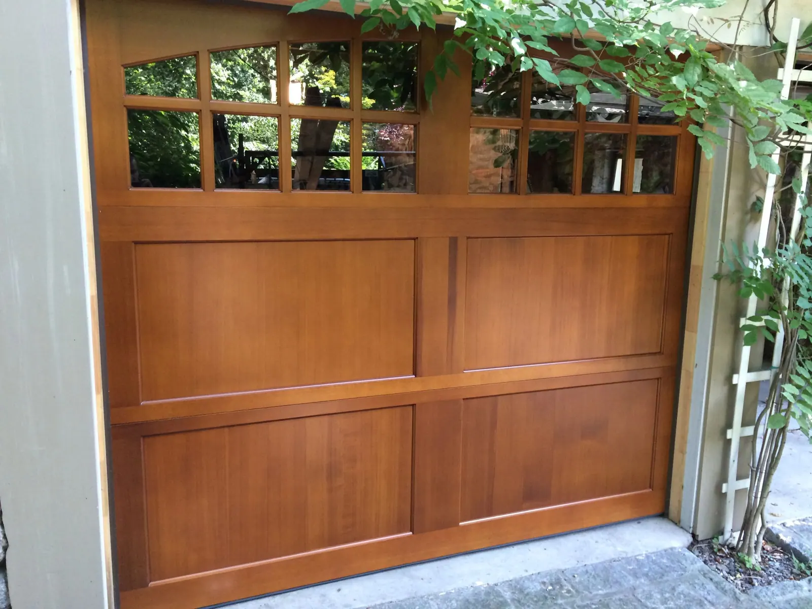 A stained cedar-wood carriage door installed by Apex Door